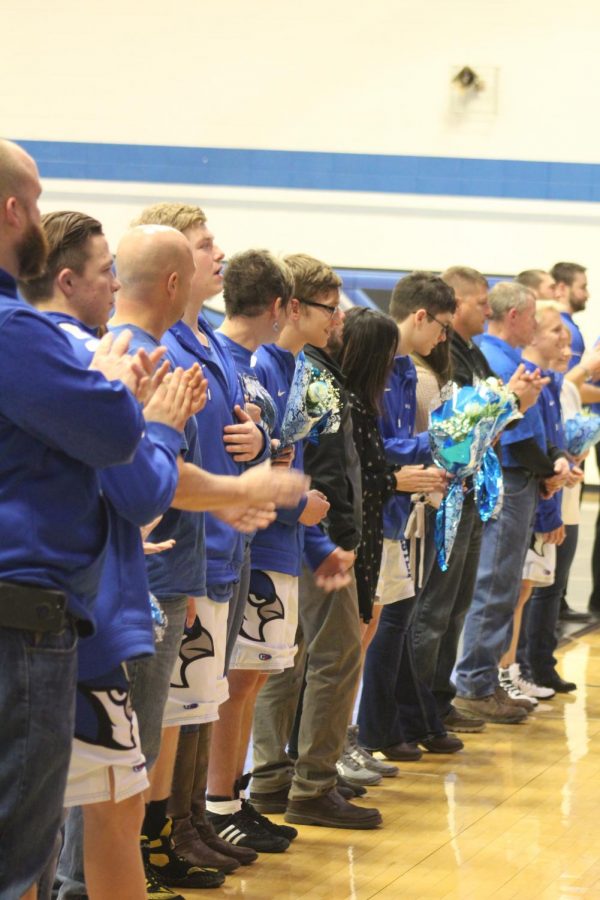 Seniors line up on senior night with their parents. 