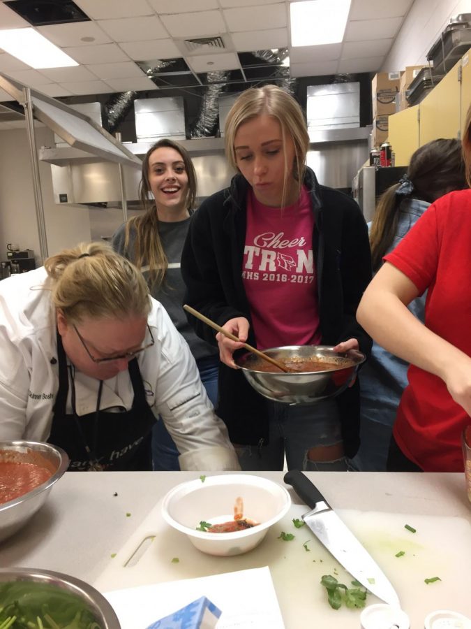 Students cook food for the Spanish Club Dinner.
